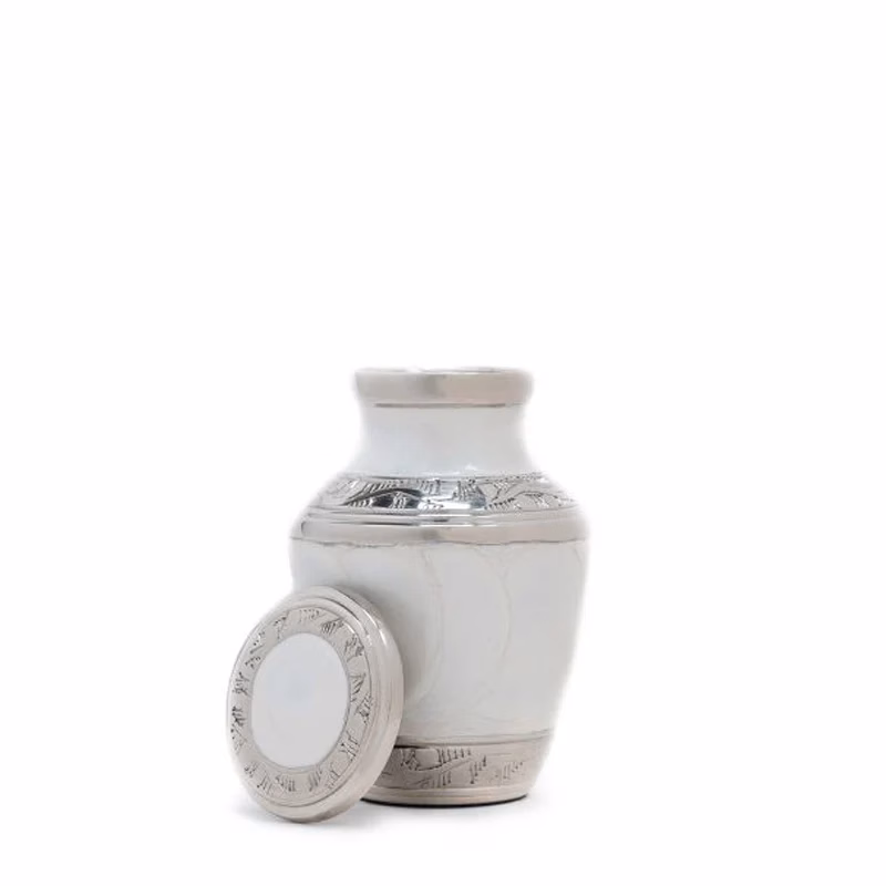 Enamel White Ripple Brass Keepsake Urn with removable lid placed beside the urn on a white background