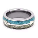 Angled top view of a polished memorial ring featuring a turquoise inlay band with a silver arrow accent and a lower channel designed to hold cremation ashes.