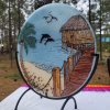 Beach Hut with Dolphins suncatcher with cremation ash shown at an angled side view with ocean pier, palm tree, and dolphins in flight