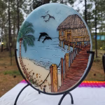 Beach Hut with Dolphins suncatcher with cremation ash shown at an angled side view with ocean pier, palm tree, and dolphins in flight