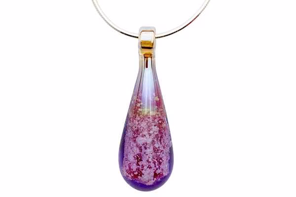 Teardrop cremation pendant in rhodolite with cremation ash suspended inside glass