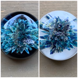 Comfort Stone with Cremation Ash shown in blue glass on black and white glass background for color comparison, by Sands of Time.