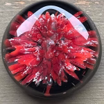 Comfort Stone with Cremation Ash shown in red glass on a black background, by Sands of Time.