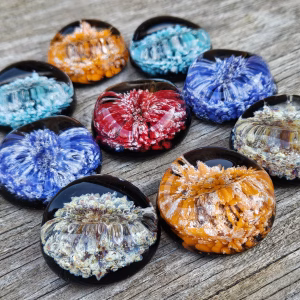 Comfort Stones with Cremation Ash shown in multiple custom color variations arranged on a rustic wooden surface, by Sands of Time.