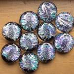 Comfort Stone with Cremation Ash shown in a turquoise and purple mixed glass color on a wooden background, by Sands of Time.