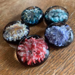 Comfort Stone with Cremation Ash displayed in multiple color variations on a wooden background, by Sands of Time.