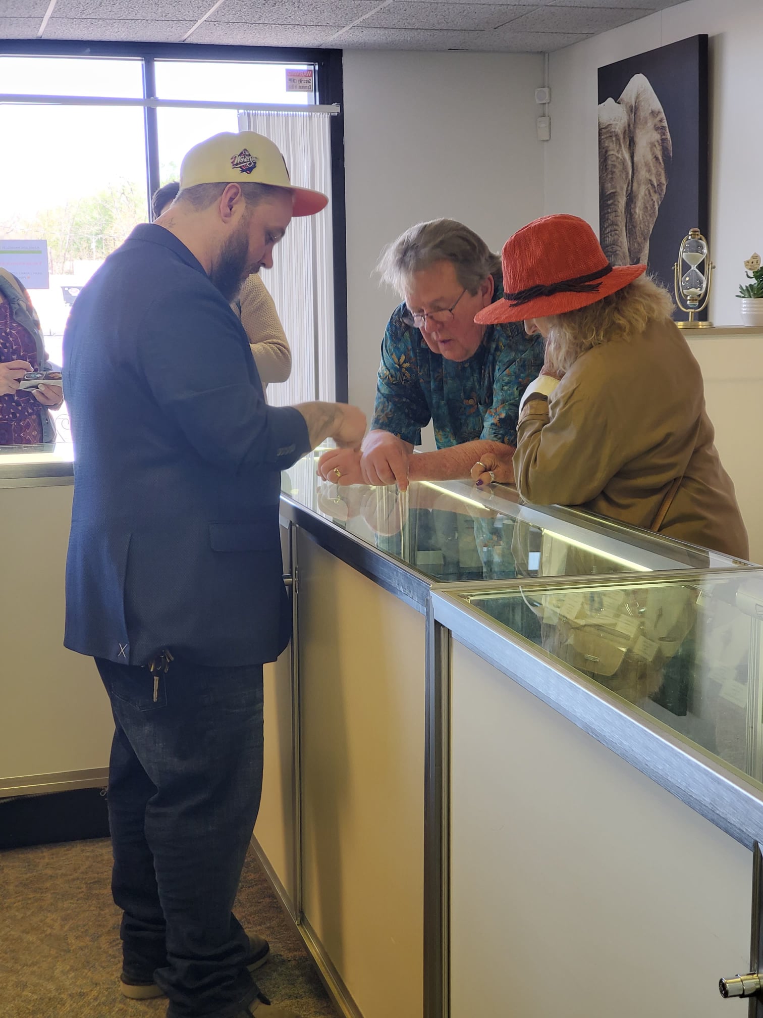 Chris Santora assisting customers at the glass display counter inside the Sands of Time Memorial Art Glass showroom