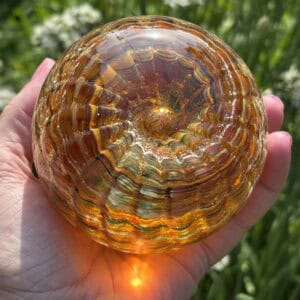Top view of citrine birthstone glass paperweight with cremation ashes in a Sparkle Ripple Vortex design