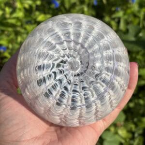 Top view of opal-inspired birthstone glass paperweight with cremation ashes in a Ripple Vortex design