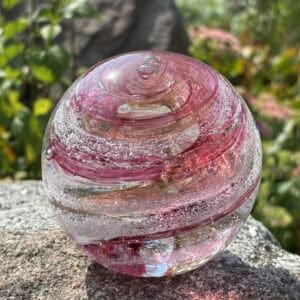 Front view of pink tourmaline birthstone glass paperweight with cremation ashes and gold sparkle in a Sparkle Swirl design