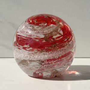 Ruby birthstone glass paperweight with cremation ashes in a red and gold Sparkle Swirl design