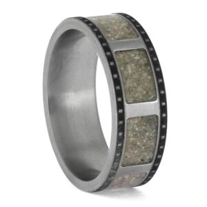 Upright angled view of titanium cremation ring with ashes and 35mm film strip design