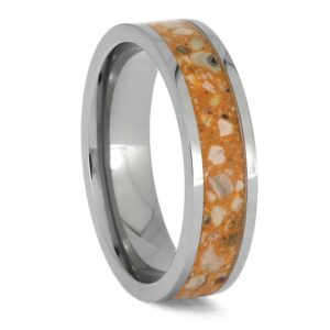 Upright angled view of titanium cremation ring with ashes preserved in an orange enamel center inlay