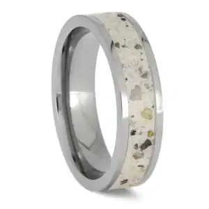 Upright angled view of polished titanium cremation ring with ashes and white enamel center inlay
