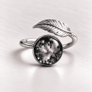Black feather glass cremation ring with ashes encased inside a handmade glass jewel and sterling silver wrap-around feather band